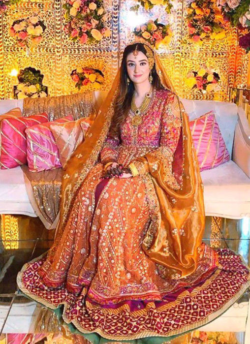 Minahil Buksh Is Resplendent In A Signature #Farahtalibaziz Kalidaar In Burnt Orange With A Vibrant Magenta Lehnga, Accentuated With Gold Embellishments And A Stunning Gold Dupatta
